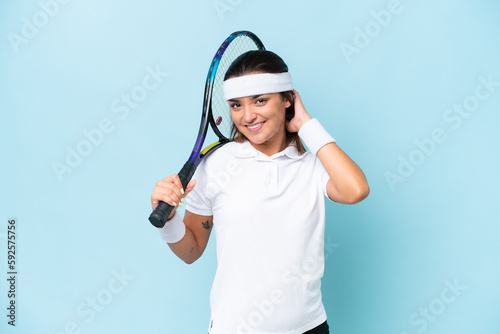 Young tennis player woman isolated on blue background laughing © luismolinero