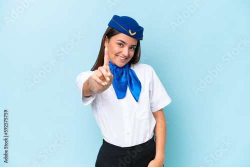 Airplane stewardess caucasian woman isolated on blue background showing and lifting a finger
