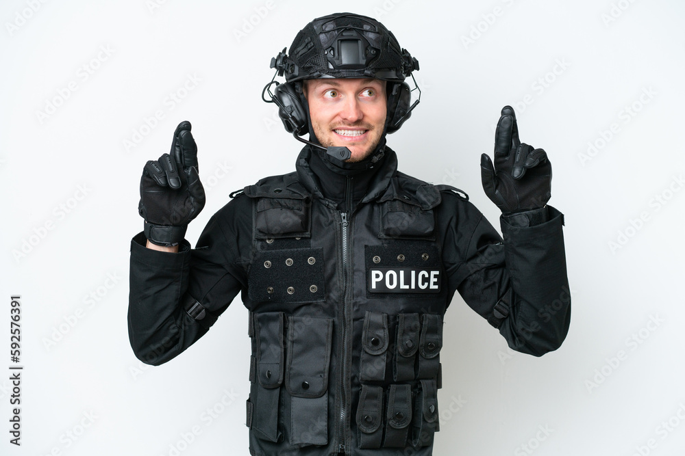 SWAT man over isolated white background with fingers crossing SWAT man over isolated white background with fingers crossing