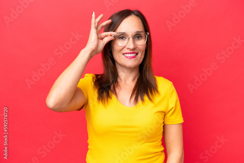 Middle-aged caucasian woman isolated on red background showing ok sign with fingers