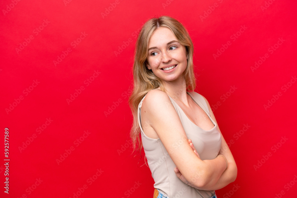 Young English woman isolated on red background looking to the side and smiling Young English woman isolated on red background looking to the side and smiling