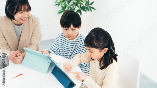 タブレットで勉強する子供たちと教える女性 photo