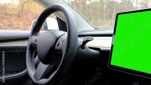 Interior dashboard with a modern interface design and steering wheel. Electronic dashboard tablet Green screen chromakey © Yuliya