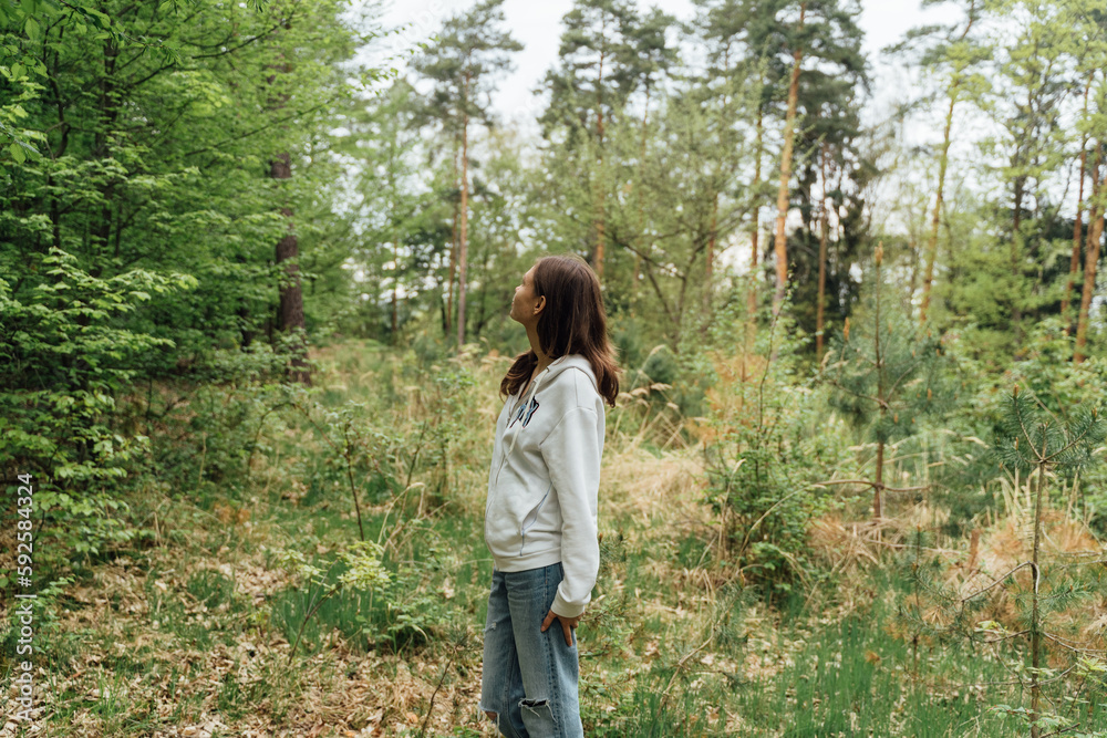 teenager gen z girl walking in the forest. close to nature concept teenager gen z girl walking in the forest. close to nature concept