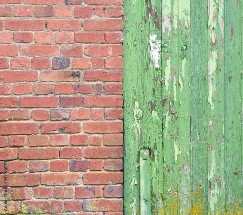 A weathered green door against a red brick wall