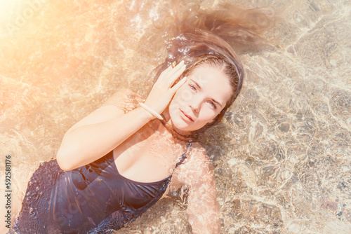 Woman summer travel sea. Happy tourist enjoy taking picture outdoors for memories. Woman traveler posing on the beach at sea surrounded by volcanic mountains, sharing travel adventure journey