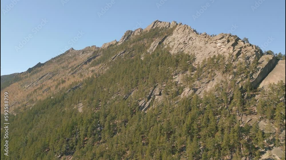 Rock covered with green forest. Aerial view of ancient mountains and stones. Rock covered with green forest. Aerial view of ancient mountains and stones.