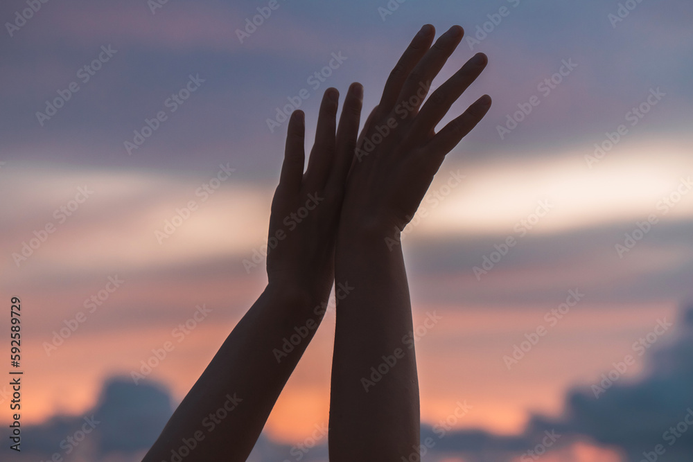 Woman hands against sunset sky. High quality photo