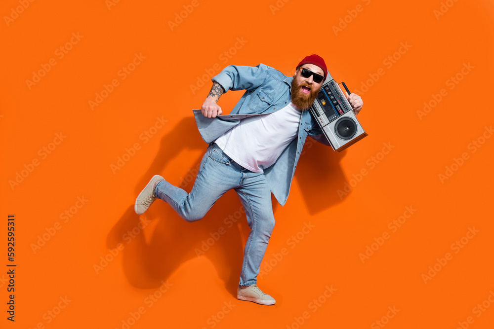 Full size photo of positive guy dancing floor listening pop song from boombox isolated vivid color background Full size photo of positive guy dancing floor listening pop song from boombox isolated vivid color background