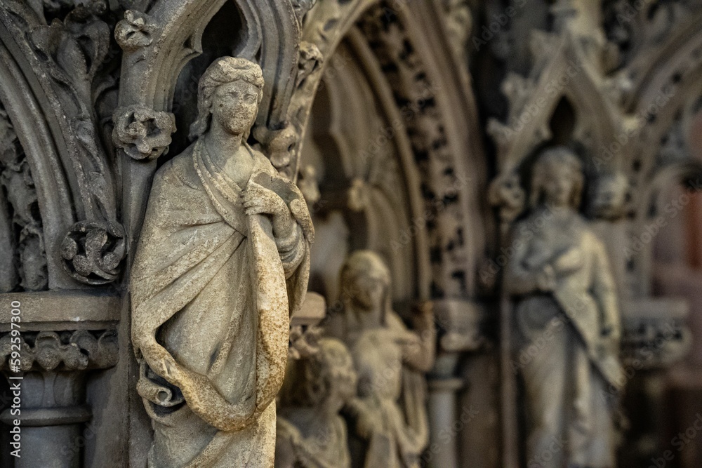 Selective focus of a gothic sculpture on the buildings exterior wall.