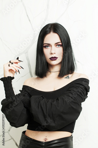 фотографія Nice brunette goth woman with black nails on white background