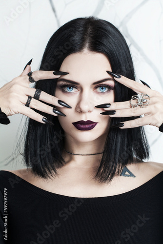 Foto Portrait of beautiful brunette woman with black nails, halloween character