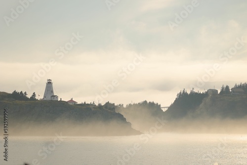 Foggy landscape with lighthouse on the background