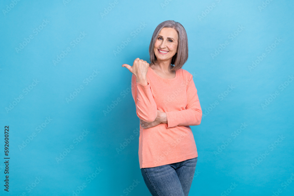 Photo of beautiful retired business woman grey hair direct finger mockup open international vacancy offer isolated on blue color background Photo of beautiful retired business woman grey hair direct finger mockup open international vacancy offer isolated on blue color background