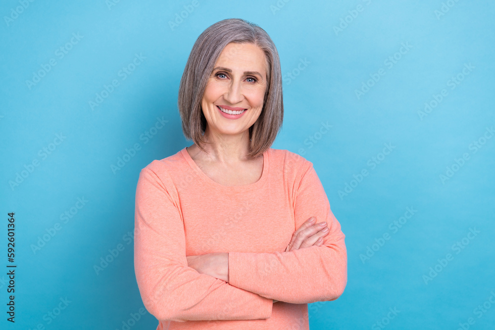 Photo of shiny confident lady dressed coral shirt smiling arms crossed isolated blue color background Photo of shiny confident lady dressed coral shirt smiling arms crossed isolated blue color background
