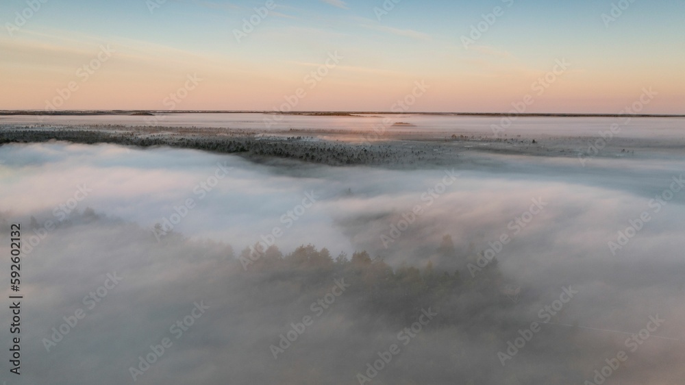 Obraz premium Beautiful view of a lake with a cloudy sky and little morning mist