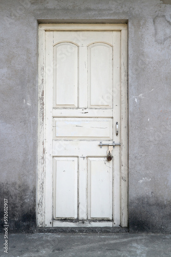 An old white wooden door, bolted and padlocked. © d_odin