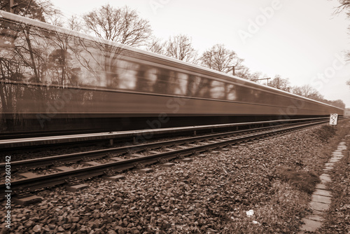 Ein Zug oder eine S Bahn fährt auf einem Gleis. Eine Langzeitbelichtung, Bewegungsunschärfe.