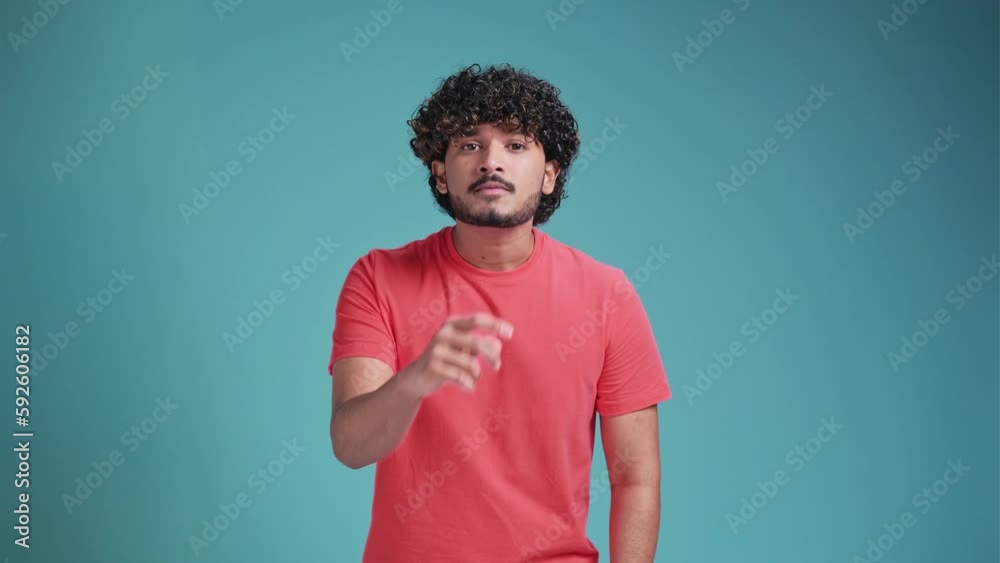 Shh be quiet please. Young indian man presses index finger to lips makes silence gesture sign do not tells secret, stop gossip. Handsome bearded hindu guy wearing coral t-shirt isolated on a blue Shh be quiet please. Young indian man presses index finger to lips makes silence gesture sign do not tells secret, stop gossip. Handsome bearded hindu guy wearing coral t-shirt isolated on a blue