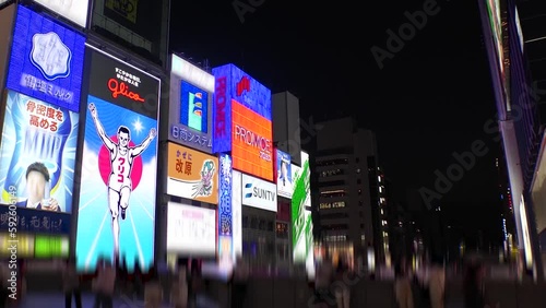 OSAKA, JAPAN : View of Dotonbori area. Tourist destinations, filled with neon signs, clubs and restaurants. Time lapse shot, sunset to night. Logo and signs are blurred or overwritten for this video. photo