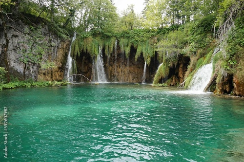 Waterfalls flowing into a blue lake at Plitvice Lakes National Park