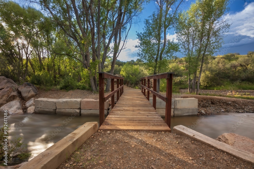 Obraz premium Beautiful view of a little bridge over Lynx Creek flowing in Fain park