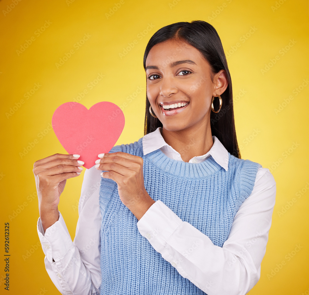 Happy, paper and heart with portrait of woman in studio for love, support and romance. Valentines day, kindness and date with female and symbol on yellow background for health, happiness and hope Happy, paper and heart with portrait of woman in studio for love, support and romance. Valentines day, kindness and date with female and symbol on yellow background for health, happiness and hope