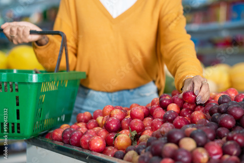 Customer hands picking fruit in supermarket. photo