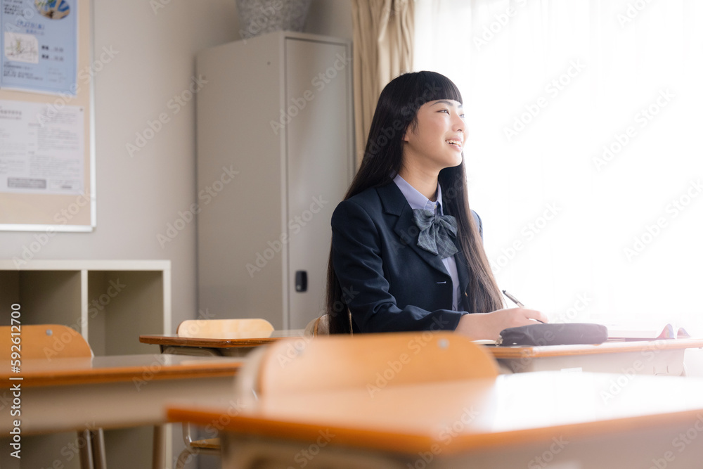 Image of junior high and high school girls studying in the evening sun in a classroom after school Looking up
Image of junior high and high school girls studying in the evening sun in a classroom after school Looking up