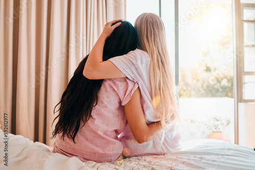 Love, bedroom and back of friends hugging for comfort, support or care while at a sleepover. Bond, romance and lesbian women couple embracing and spending quality time together in their apartment.