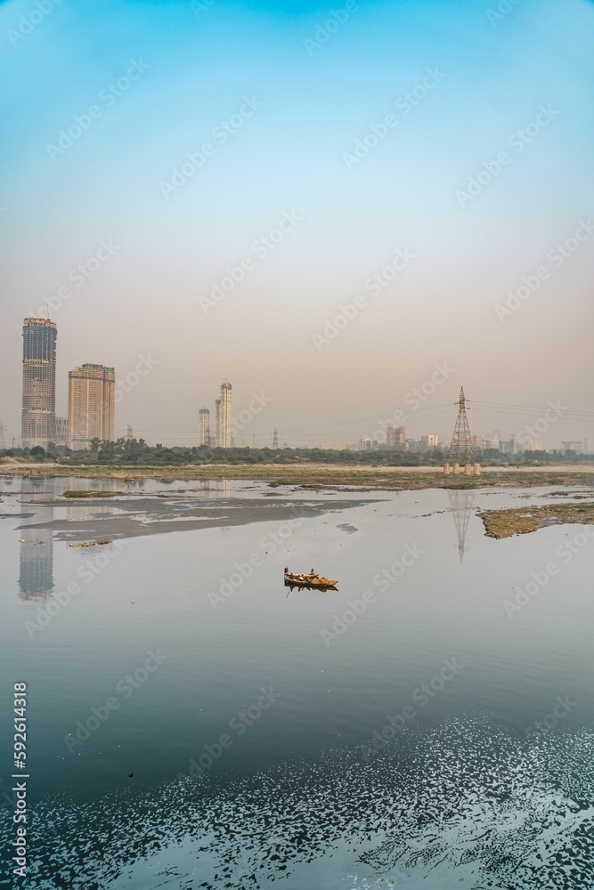 Vertical shot of a boat on the Yamuna river against the background of the blue sky. Delhi, India.