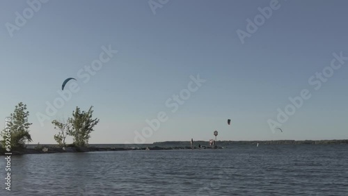 Kiteboarding sails in the sky above the Somcoe lake in Sibbald Point Provincial Park, Canada