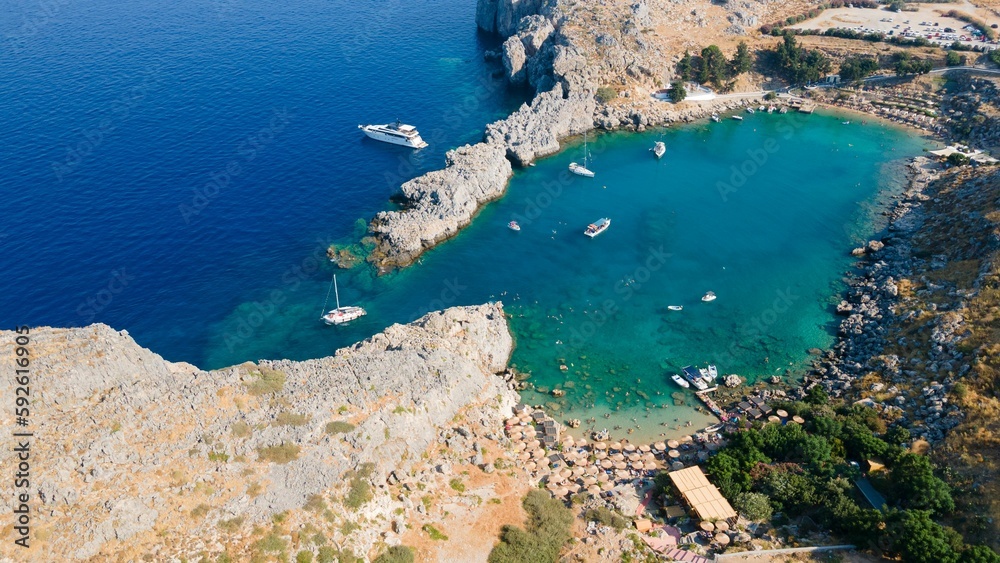 Aerial view of a rocky bay with ships on a sunny day