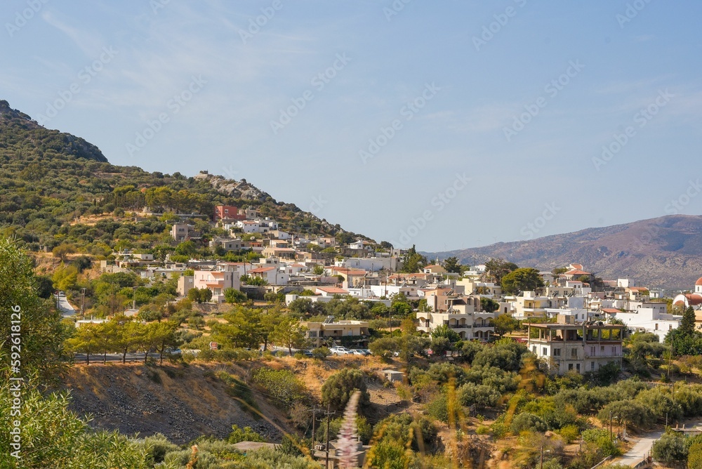 Beautiful shot of a city on mountain with greenery under blue sky