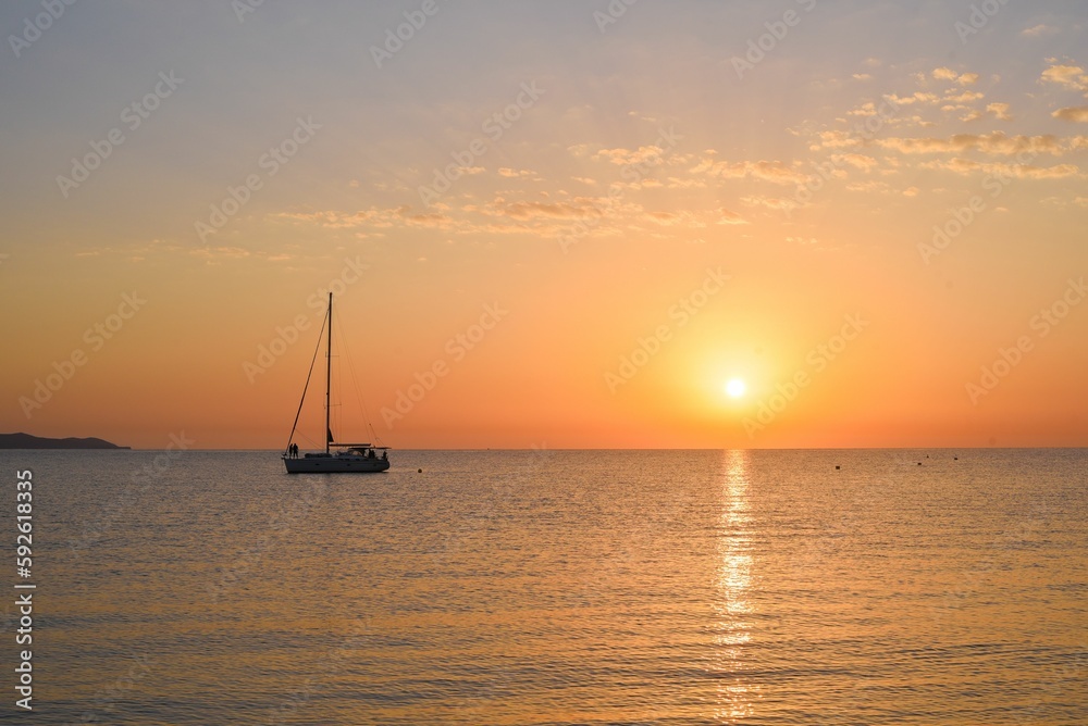 Sea with a sailboat against the beautiful background of the sky at sunset.