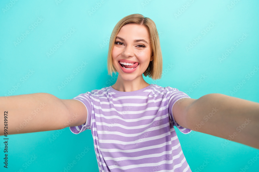 Photo of funky optimistic girl with bob hairstyle wear striped t-shirt make selfie lick lips isolated on turquoise color background Photo of funky optimistic girl with bob hairstyle wear striped t-shirt make selfie lick lips isolated on turquoise color background