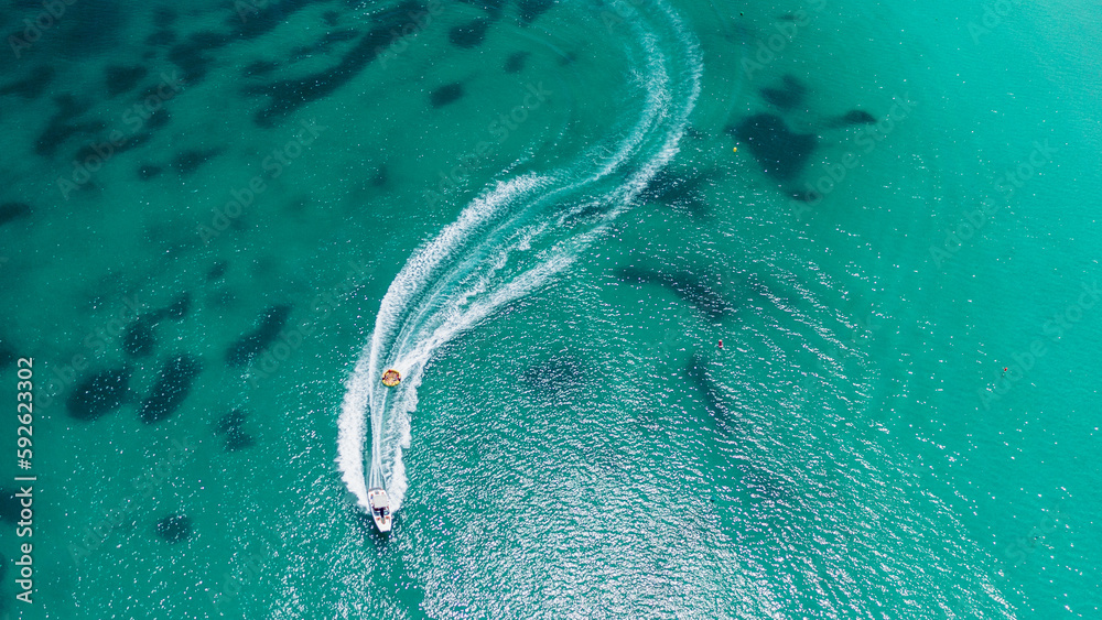 Aerial view on motorboat and jetski on the sea surface.