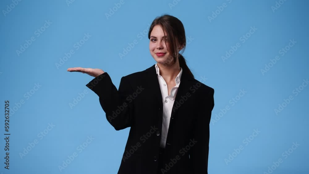 4k video of one girl who showing something in his right hand over blue background. 4k video of one girl who showing something in his right hand over blue background.