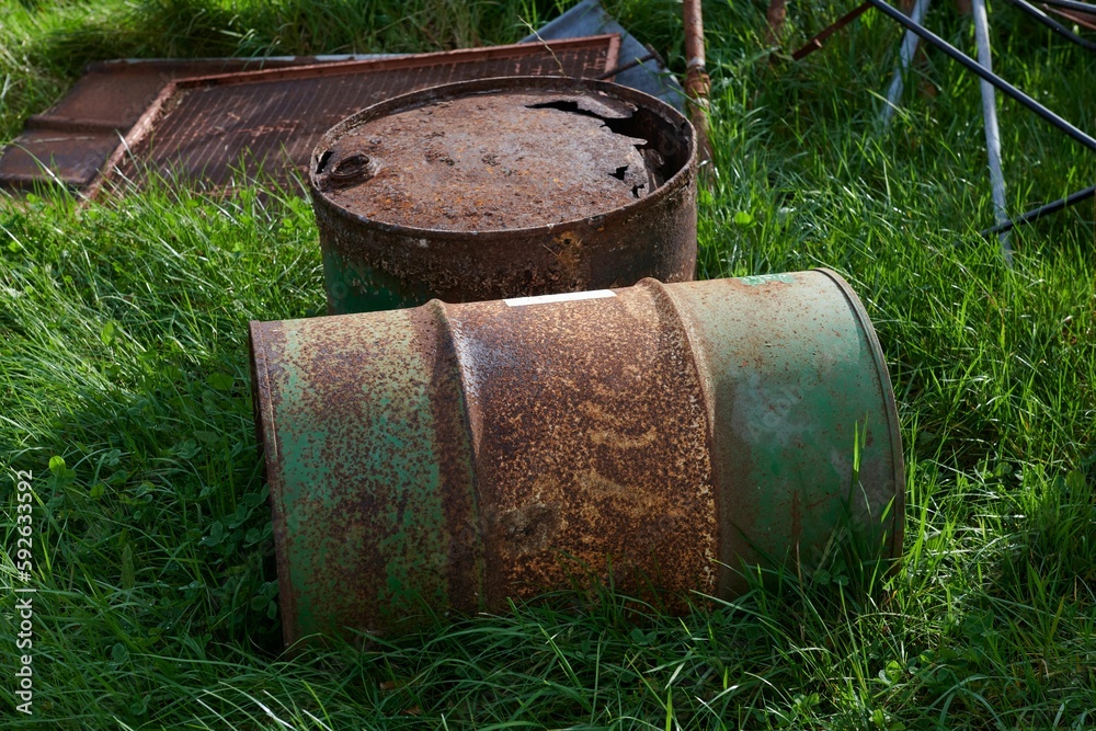 Two rusty barrels on green grass - ecology concept Two rusty barrels on green grass - ecology concept