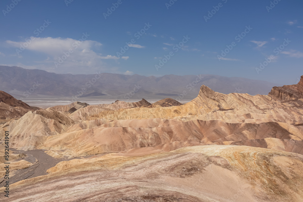 Scenic view of Badlands of Zabriskie Point, Furnace creek, Death Valley National Park, California, USA. Erosional landscape of multi hued Amargosa Chaos rock formations, Panamint Range in the back