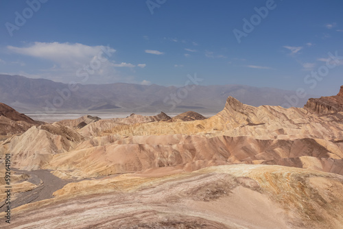 Scenic view of Badlands of Zabriskie Point  Furnace creek  Death Valley National Park  California  USA. Erosional landscape of multi hued Amargosa Chaos rock formations  Panamint Range in the back