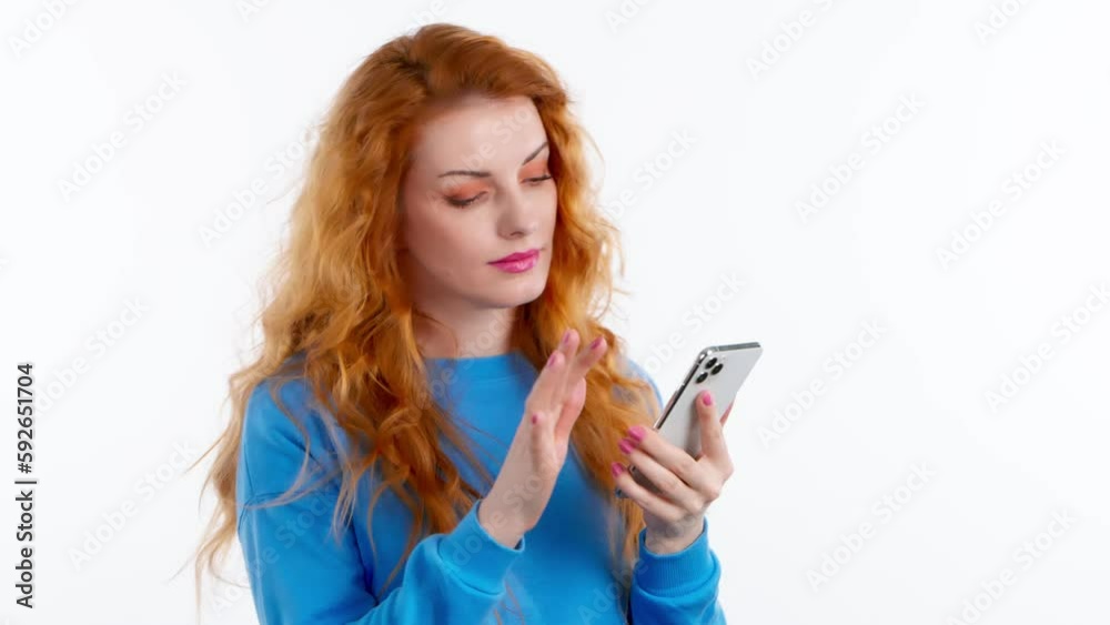 Surprised young woman pointing at mobile phone. Wow! Lady amazed excited with smartphone for social media, online streaming, news and internet, surprise face. Studio shot isolated on white background Surprised young woman pointing at mobile phone. Wow! Lady amazed excited with smartphone for social media, online streaming, news and internet, surprise face. Studio shot isolated on white background