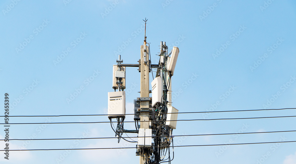 Group box Communication tower telephone pole wireless technology signal future with electric wire tangle. Telecommunication tower of 4G and 5G cellular. Antennas mounted. Sunlight cloud sky background