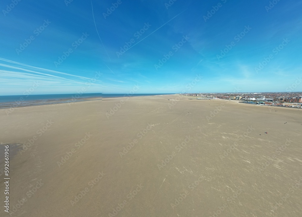 Aerial view of golden sand beach with low tide and blue sky background. Taken in Lytham Lancashire England. 