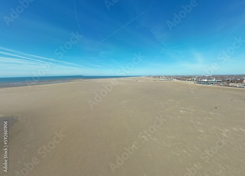 Aerial view of golden sand beach with low tide and blue sky background. Taken in Lytham Lancashire England. 