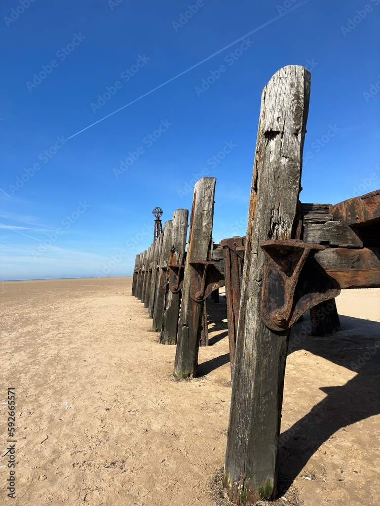 Old wooden pier On St Anne's beach in Lytham Lancashire England. Blue sky background and no people. 