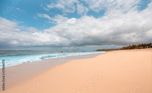 Empty tropical sandy beach and clear sea background with traditional balinese boats at amazing sunset - Bali  Indonesia