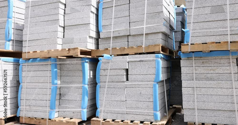 Stacked stone paving slabs lying on wooden trays 4k movie slow motion. Sale of building materials concept