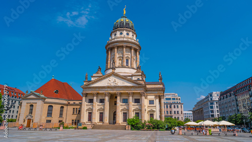 View over the Gendarmenmarkt in Berlin with French Cathedral in historical and business downtown at summer sunny day and blue sky.