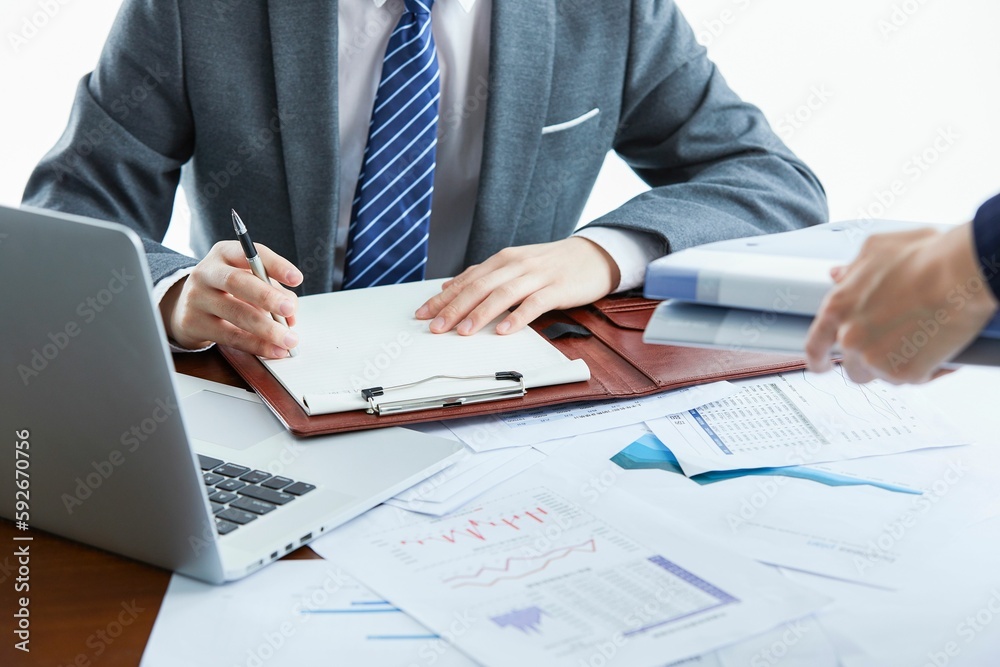 Selective focus shot of a business man using a laptop and touching some paper files. Selective focus shot of a business man using a laptop and touching some paper files.